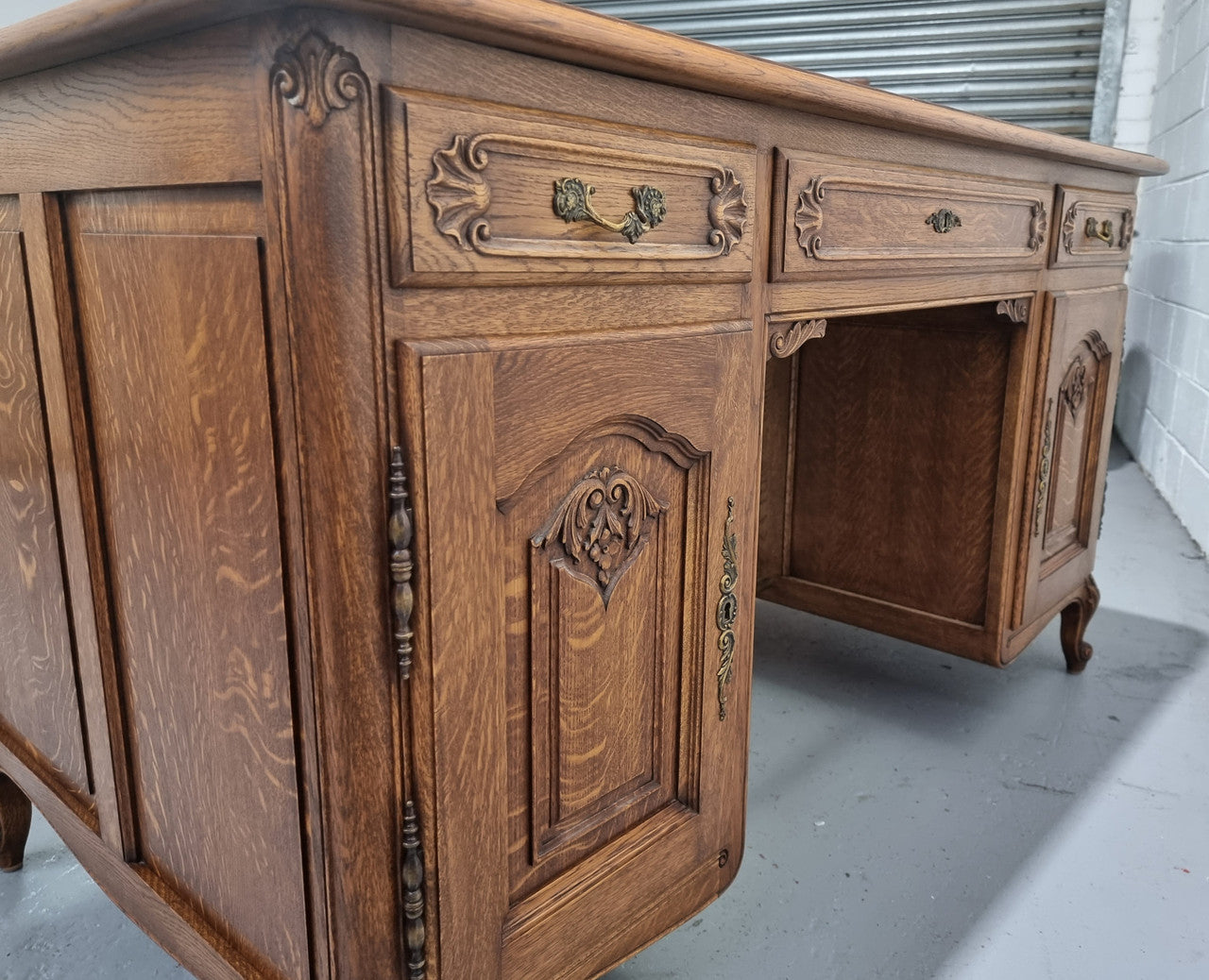 Fabulous French oak carved partners desk with a lovely parquetry top. It has three drawers and two cupboards on one side and two cupboards on the other side with no functioning drawers. It is in good original detailed condition.