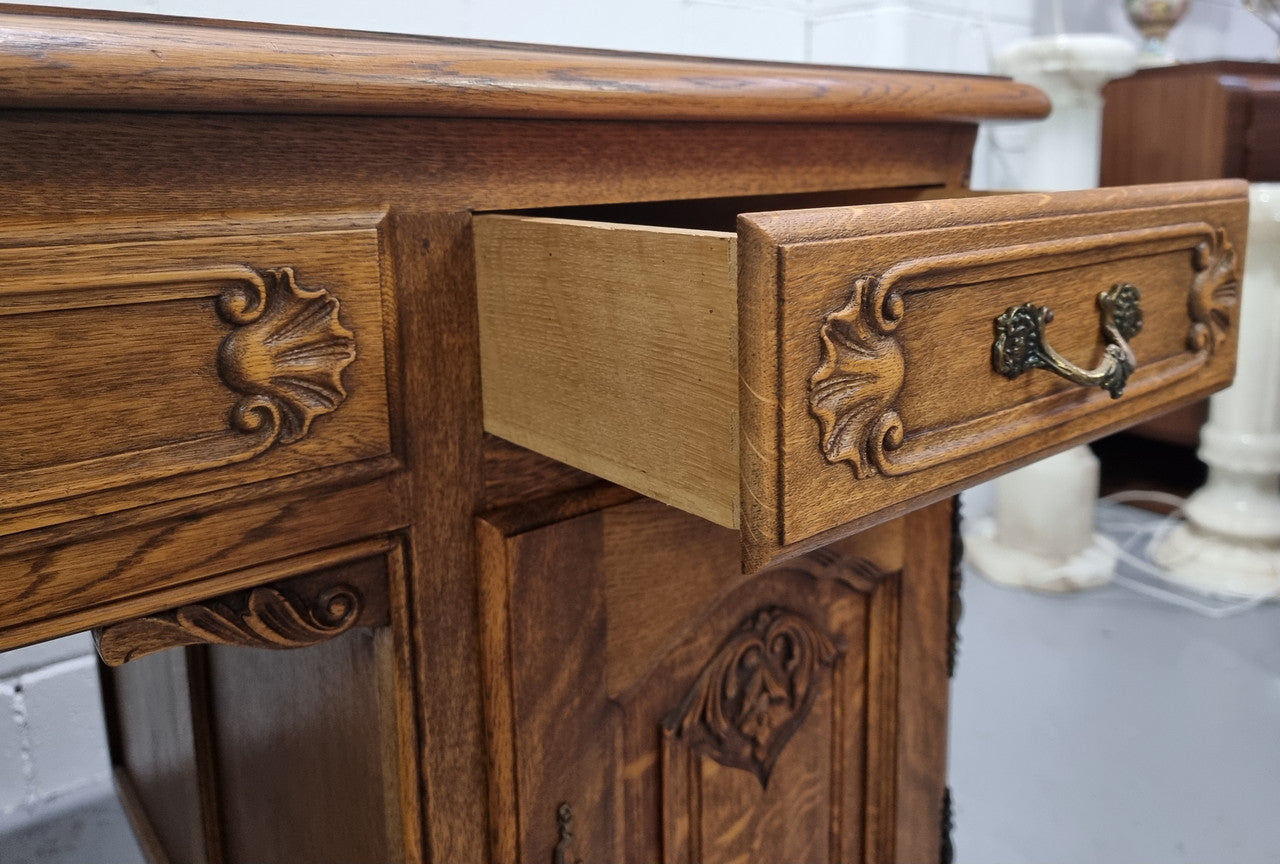Fabulous French oak carved partners desk with a lovely parquetry top. It has three drawers and two cupboards on one side and two cupboards on the other side with no functioning drawers. It is in good original detailed condition.