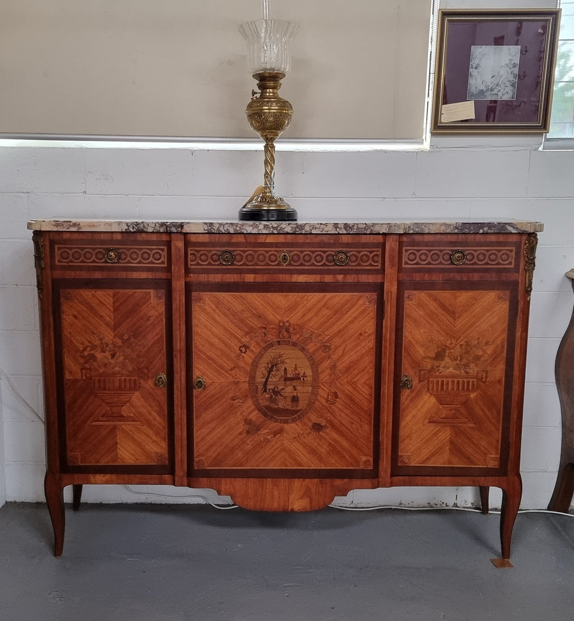 A high quality 19th Century French marquetry inlaid Kingwood marble top credenza. It has an attractive solid marble top and decorative marquetry inlay throughout. It has plenty of storage space with three drawers and three doors. It has been sourced from France and is in good original detailed condition.