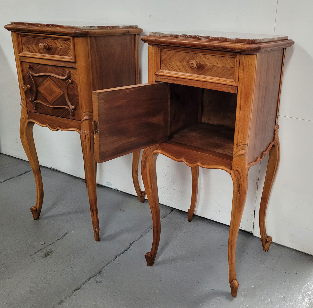 Pair French Walnut Louis XV style Bedside Cabinets with inset rouge carrera marble tops and parquetry inlay. Consisting of one drawer and one cupboard on very elegant legs. Circa: 1900's.