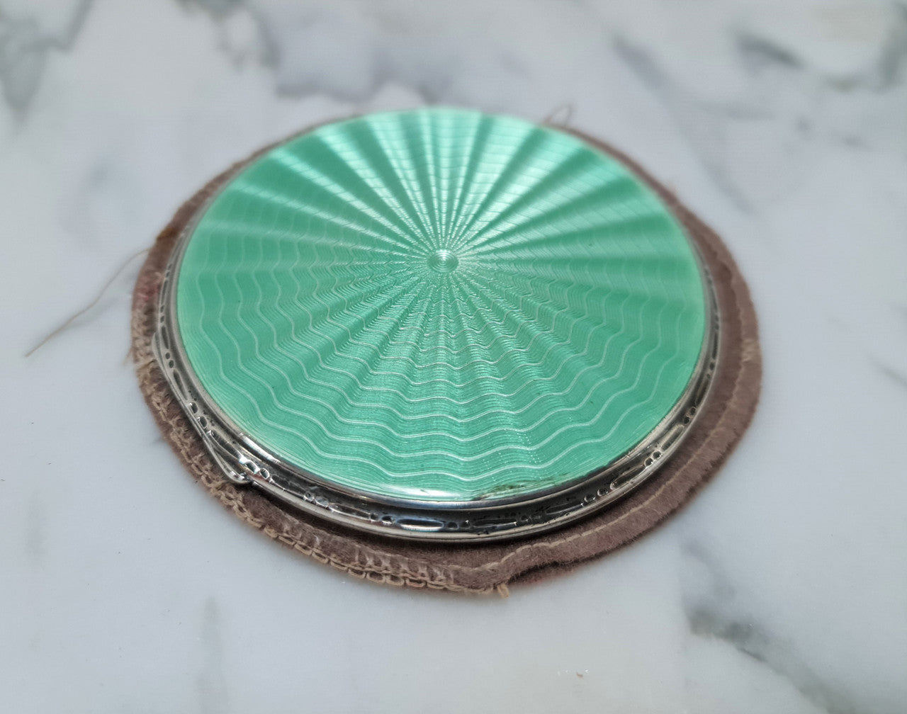 This beautiful sterling silver compact with interior mirror has a stunning mint green guilloche top in very good condition . It is marked "Birmingham 1937".