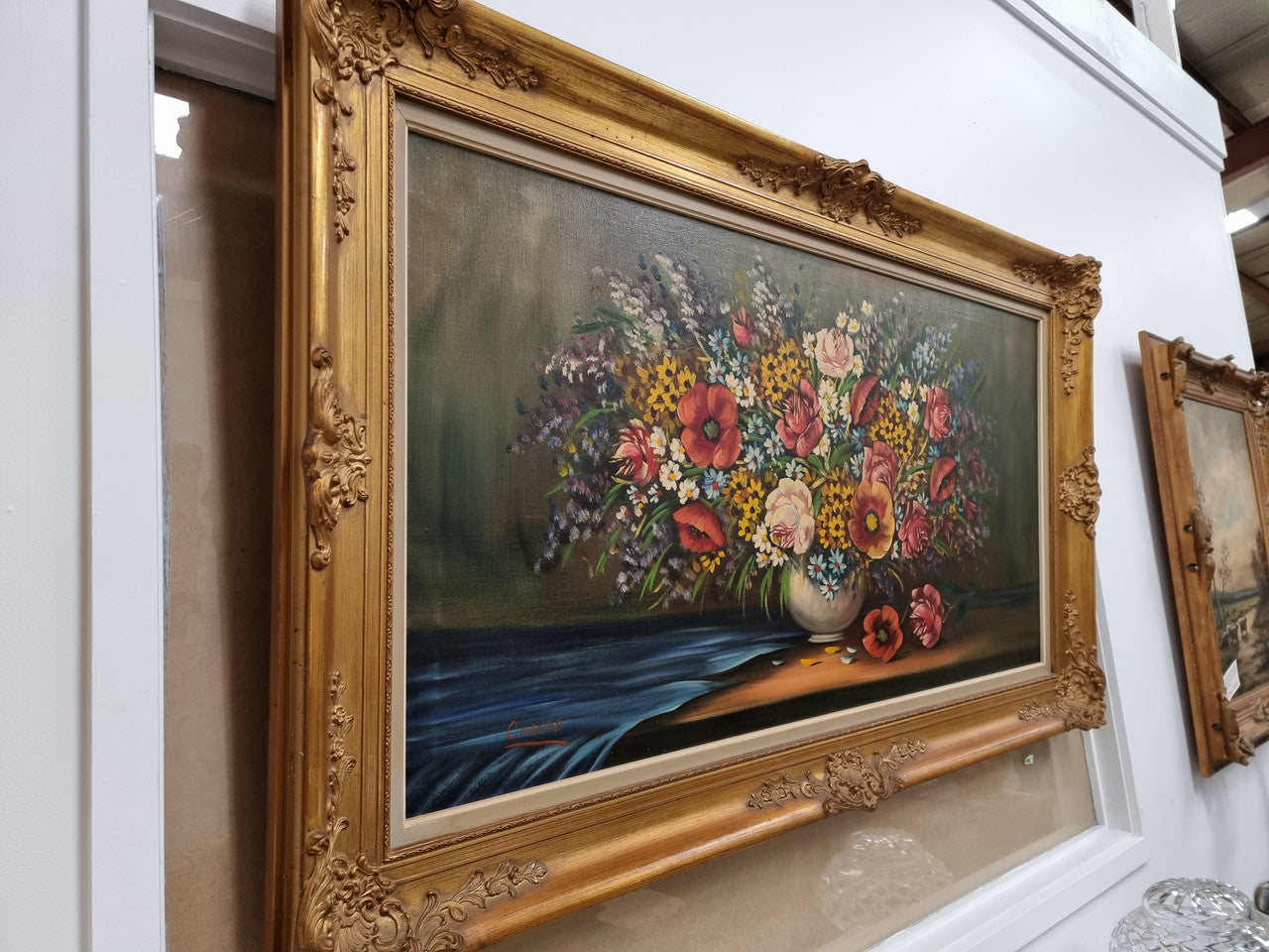 Sourced from France a stunning colorful floral oil painting on canvas. It is in a decorative gilt frame and is signed. It is in good original detailed condition.