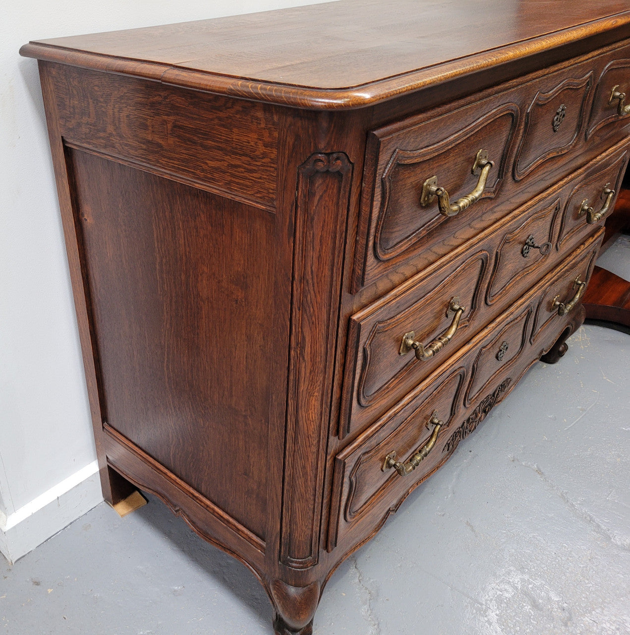 French Provincial Oak three drawer wooden top commode. It has elegant carvings and handles. It has been sourced from France and is in good original detailed condition.