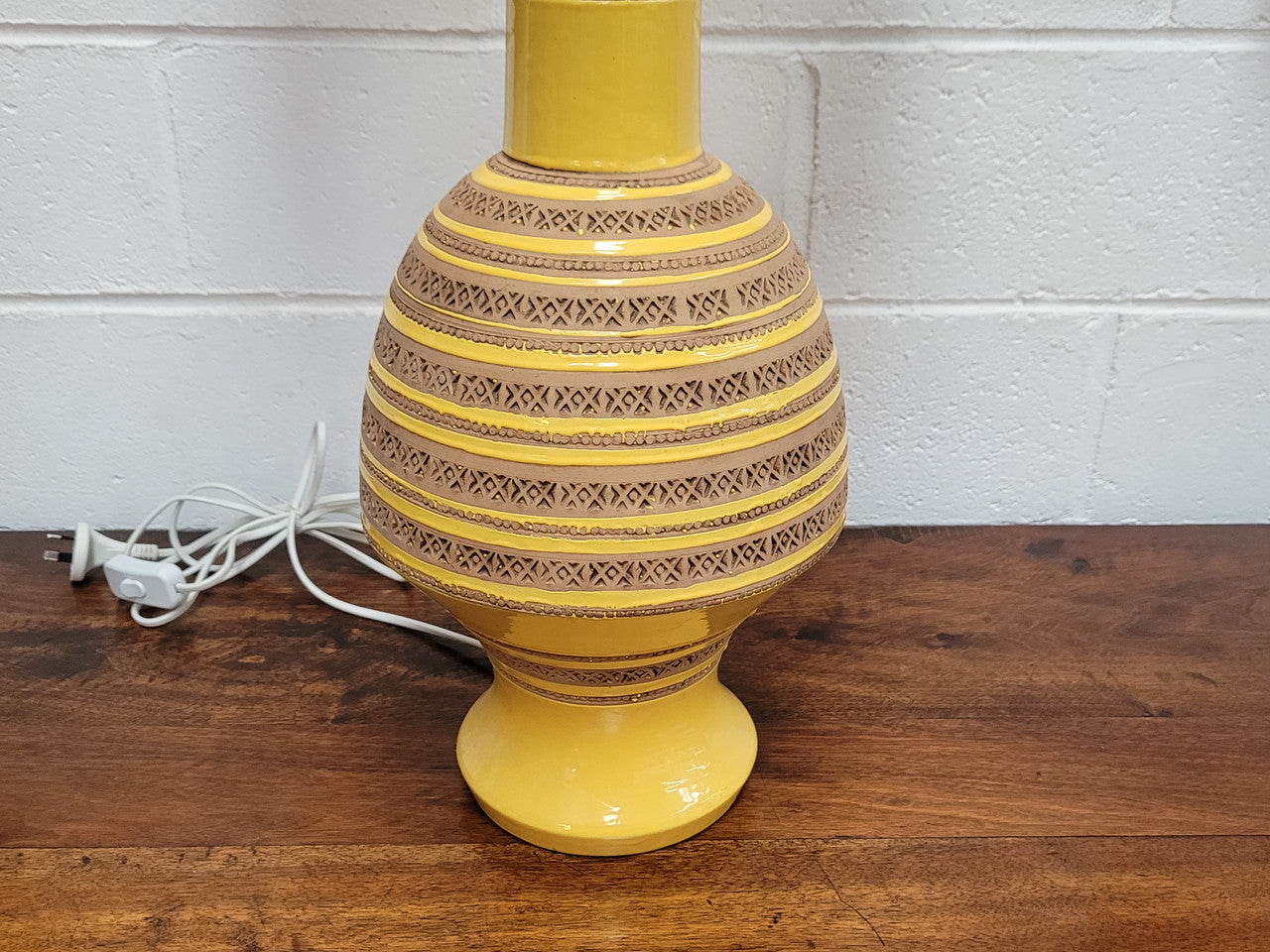 A large and impressive Vintage Mid-Century Bitossi Italian terra cotta lamp base and shade. Incised repeating geometric terra cotta pattern creates a tactile element which is incorporated with stunning shining thick yellow glaze to create the sculptural form of the base.
