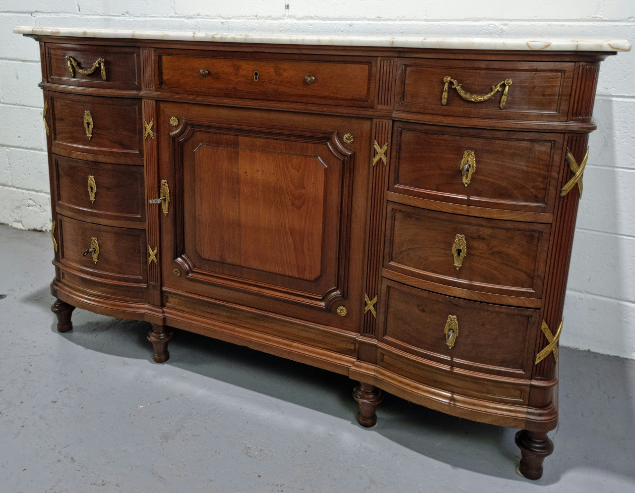 Fabulous French Walnut Louis XVI style cupboard, with a lovely marble top and nine drawers. There is also a cupboard and beautiful ormolu mounts. It is in good original detailed condition.