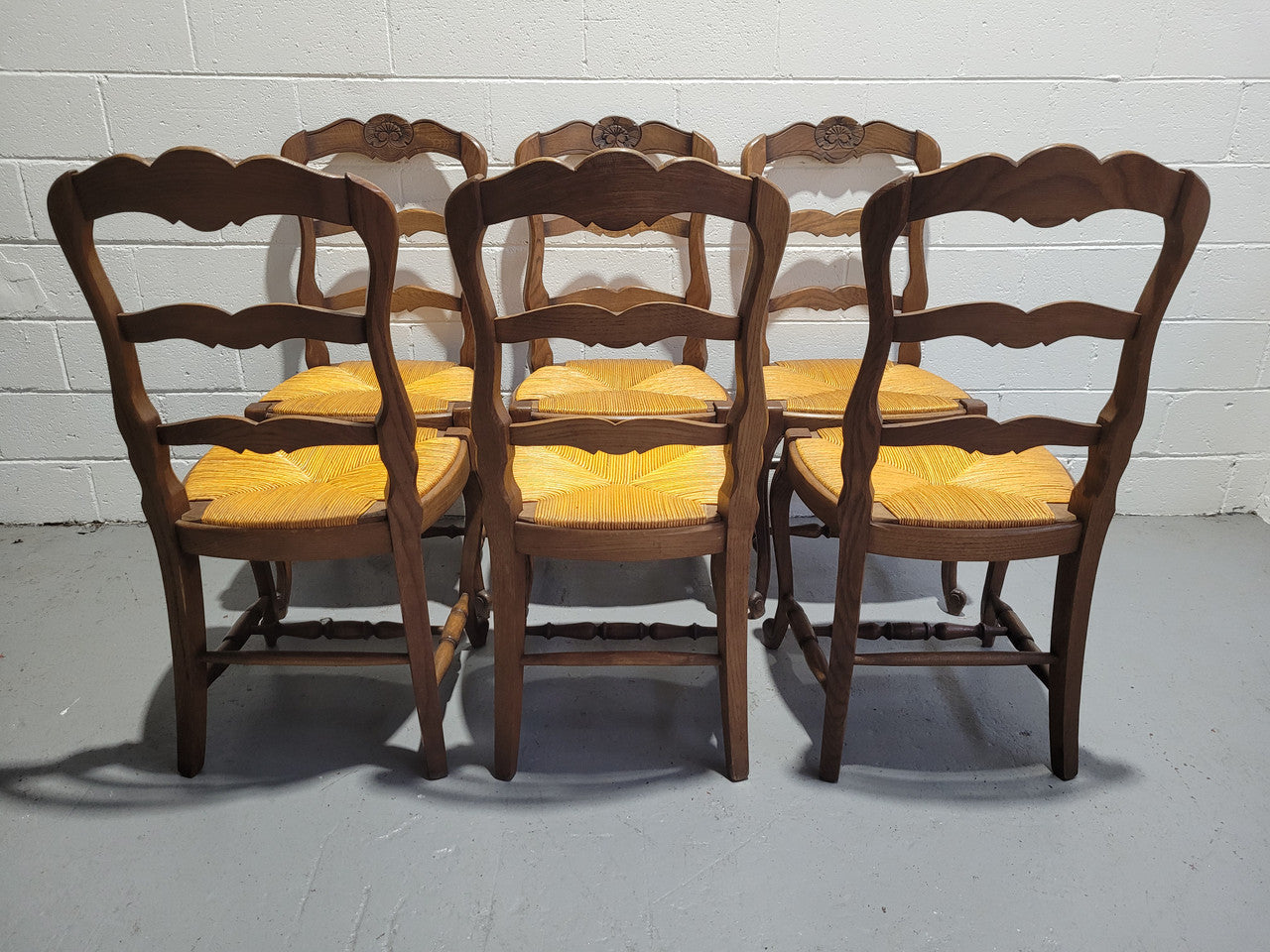 A set of 6 French Louis XV style oak dining chairs with rush seats in good original condition. All chairs have been detailed and re-glued where needed.