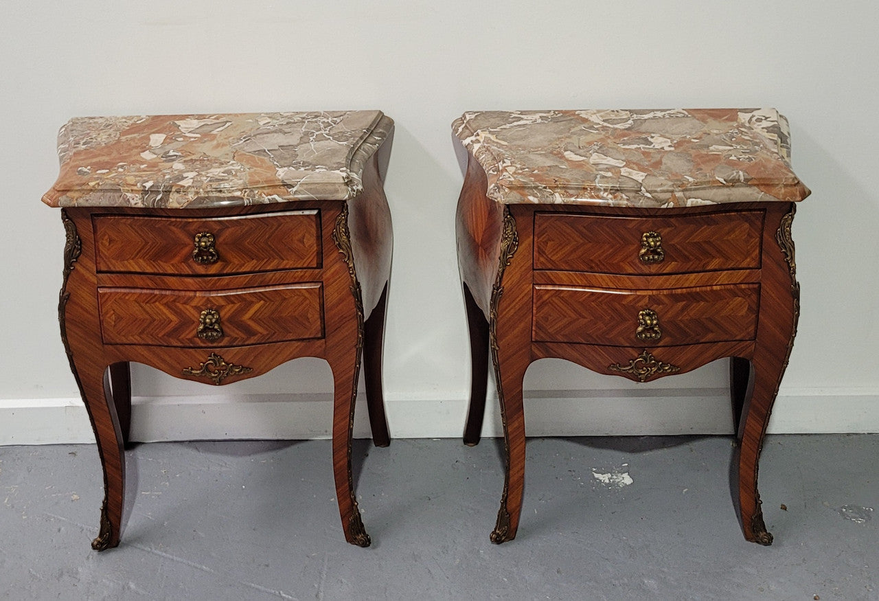 Pair of Louis XV commode style two drawer bedsides with beautiful marble tops and decorative mounts. They are a rare size and are in good, detailed condition.