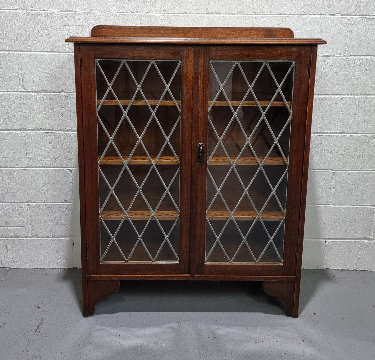 Lovely leadlight two door Oak bookcase/display cabinet with four wooden shelves. It is in good original detailed condition.
