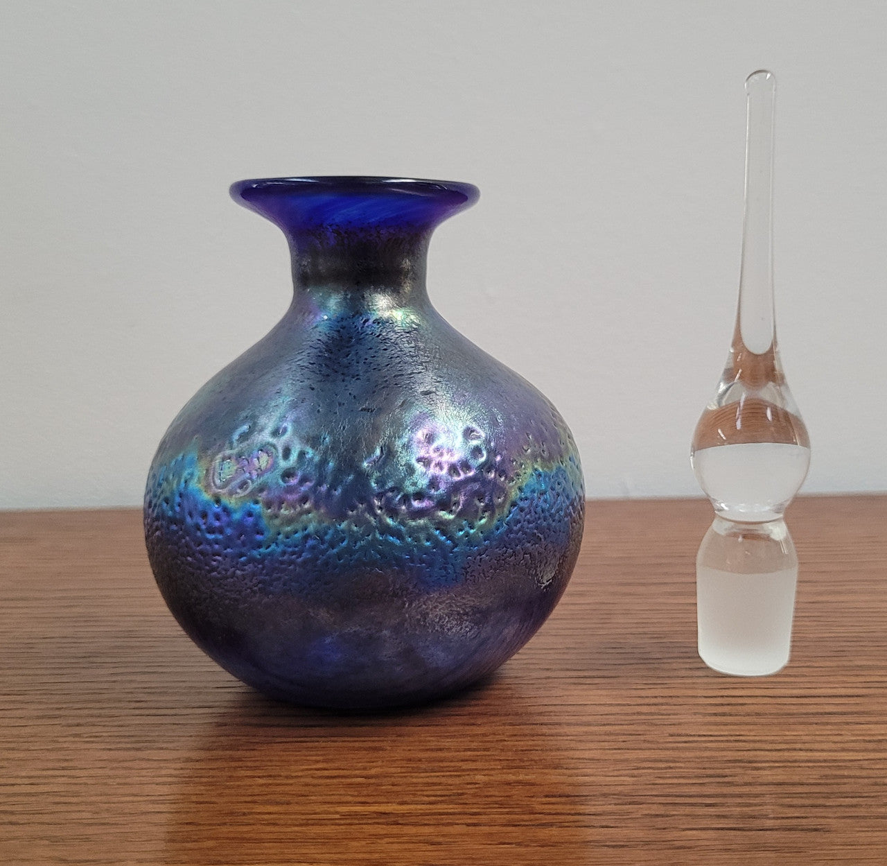 Stunning iridescent hand blown perfume bottle. Beautiful peacock blue, purple colours. Signed on base with clear glass stopper.
