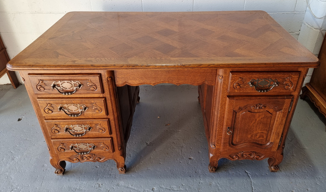 Beautifully carved french oak, faux partners desk with a lovely parquetry top and 6 drawers and 1 cupboard . In good original condition.