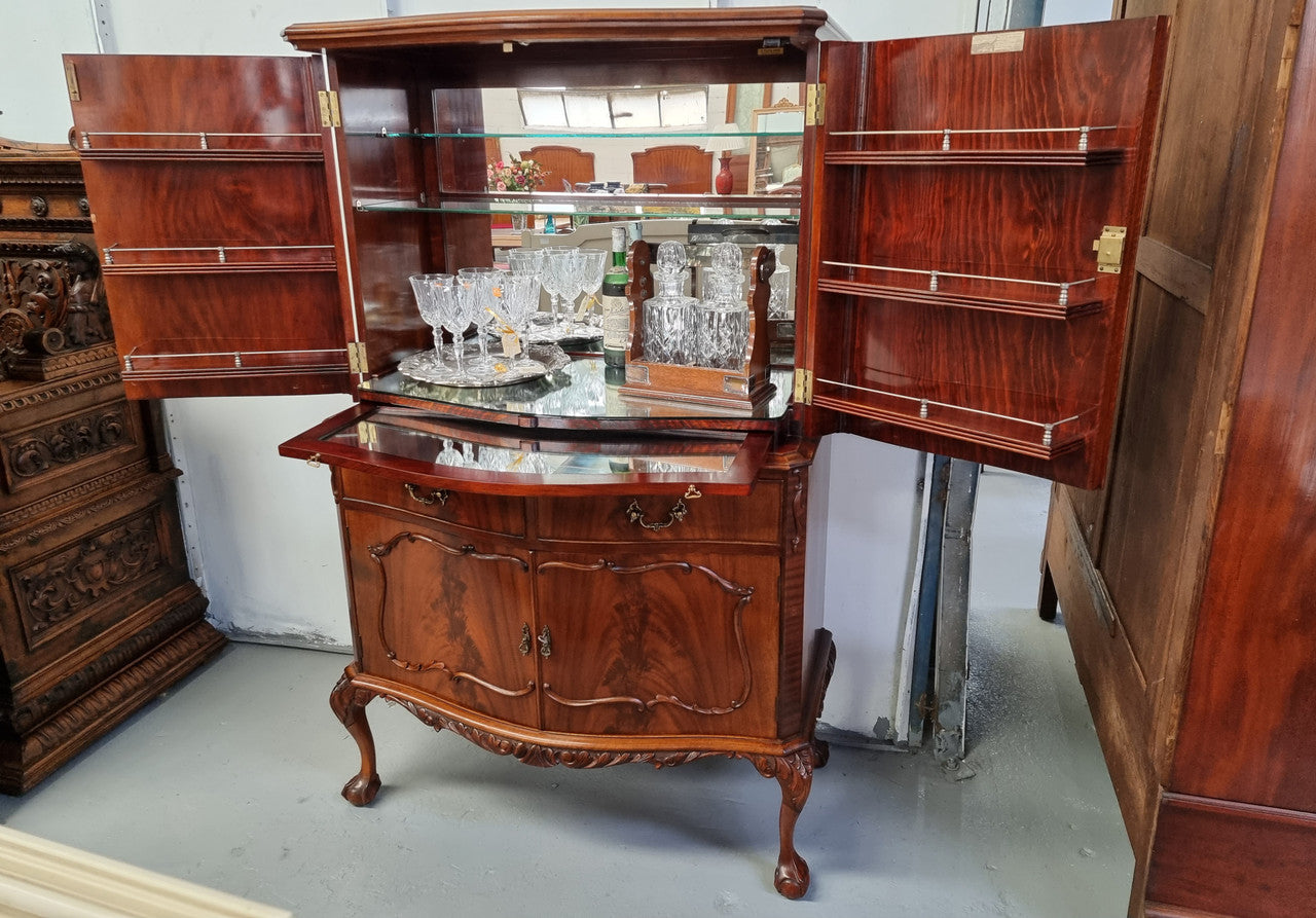 1950’s Chippendale Style Flame Mahogany Four door Bar. The top section has glass shelves and a mirrored pull out tray for storing glasses, decanters & serving etc. It also has a silver presentation plaque to the Mayor of Hawthorn 1958. The bottom section is for storage bottles etc. A stunning and practical piece.
