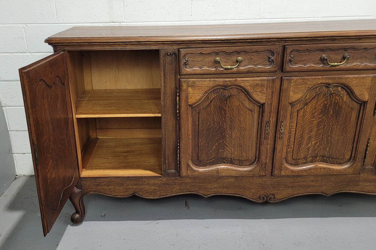 Late 19th Century French carved Oak Louis XV style four drawer sideboard. Plenty of storage space with four cupboards and two drawers. It is in good original detailed condition with all locks functioning with keys.