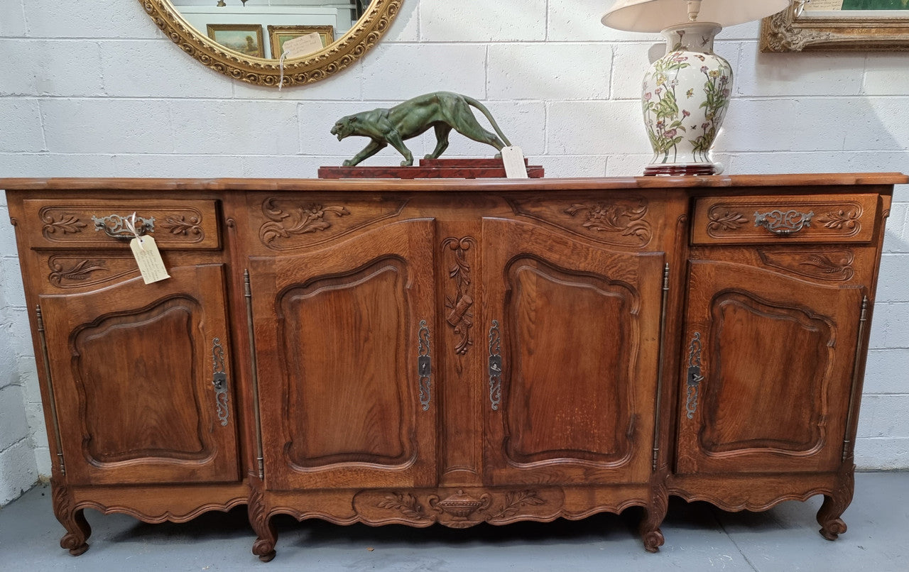 Parquetry top French oak Louis XV style sideboard with two draws and four cupboards. In good original detailed condition.