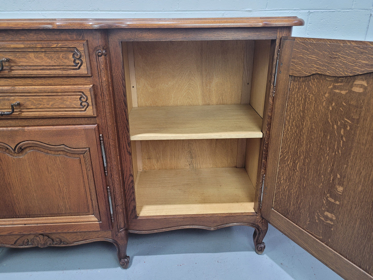 French Louis XV style parquetry top three door sideboard with two drawers. Plenty of storage space with a shelf behind each door. It is in good original detailed condition.