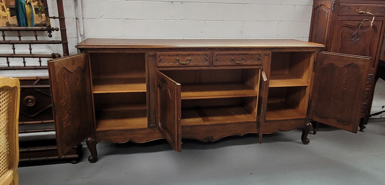 Louis XV style French Oak sideboard consisting of four doors and two drawers. It is in good restored condition.
