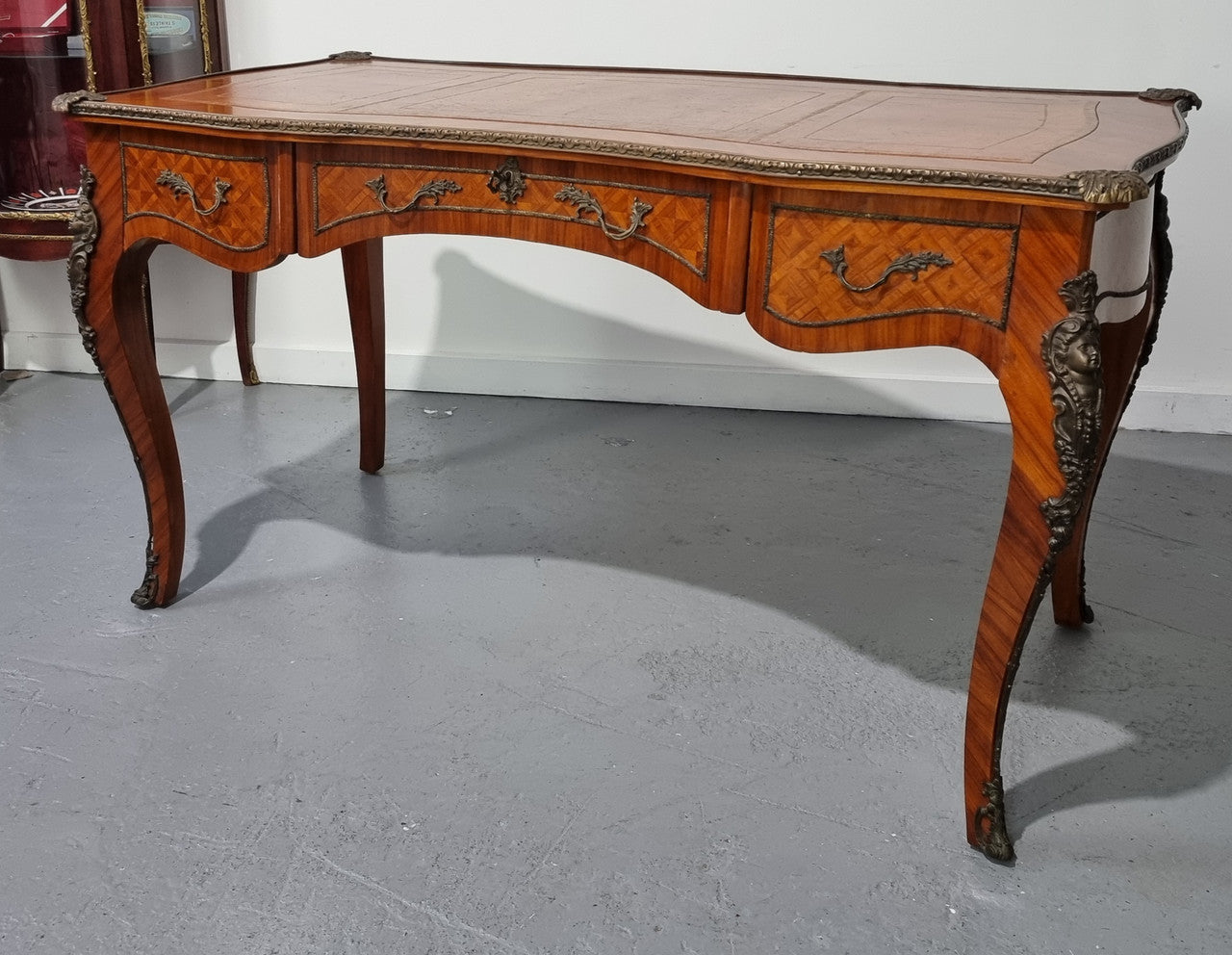 An impressive French kingwood and ormolu mounted bureau plat. It has a brown tooled leather writing surface, three decorated frieze drawers to the shaped apron with foliate swing handles and well cast figural mounts. Beautiful cabriole legs with decorative ormolu mounts and trims throughout. In good original detailed condition.