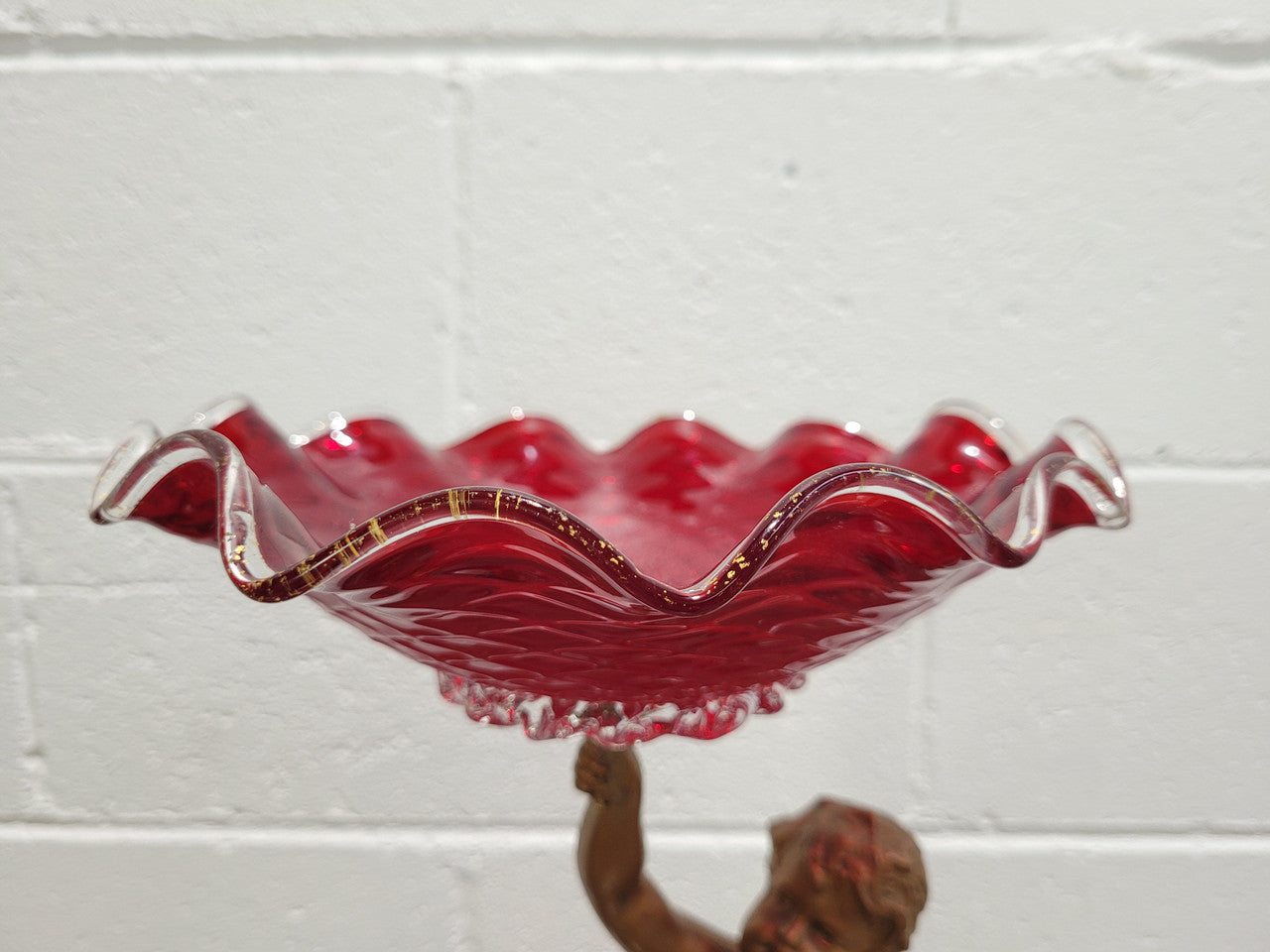 Late Victorian spelter table centerpiece/comfort featuring putti holding ruby glass bowl. In good original condition with no damage to the glass.