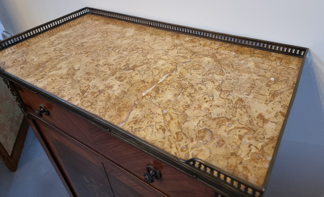 Louis 16th style marquetry inlaid side cabinet with a pierced brass gallery surrounding a marble top. It has two doors open up to storage with one shelf and a drawer above that. In good original detailed condition.