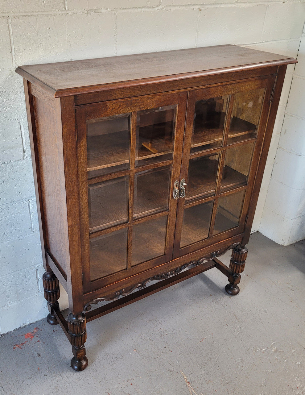 Tudor oak 2 door astral glaze and beveled glass bookcase. Good original condition. Circa 1930s.