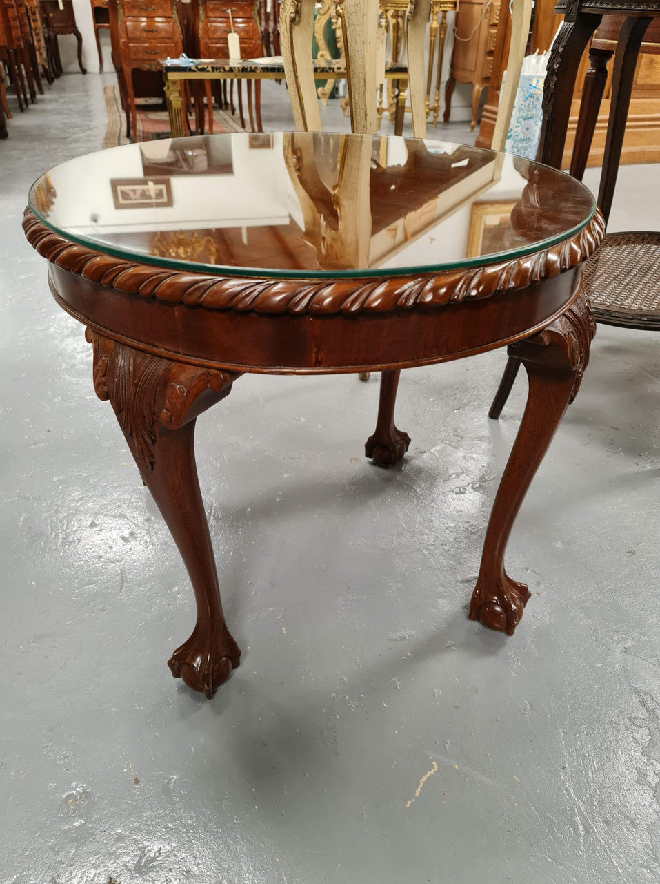 A beautiful round Mahogany Chippendale style coffee table with a glass top. In good original detailed condition.