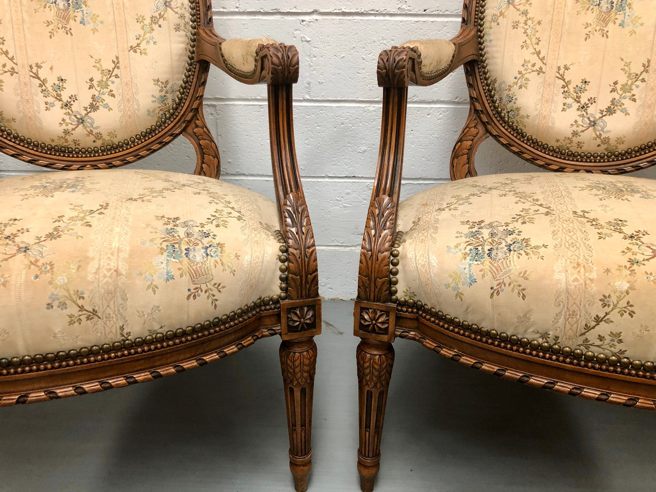 Pair of Antique French Louis XVI style carved Walnut fauteuils in restored condition. The Tapestry upholstery is in good condition some marks and wear but usable.