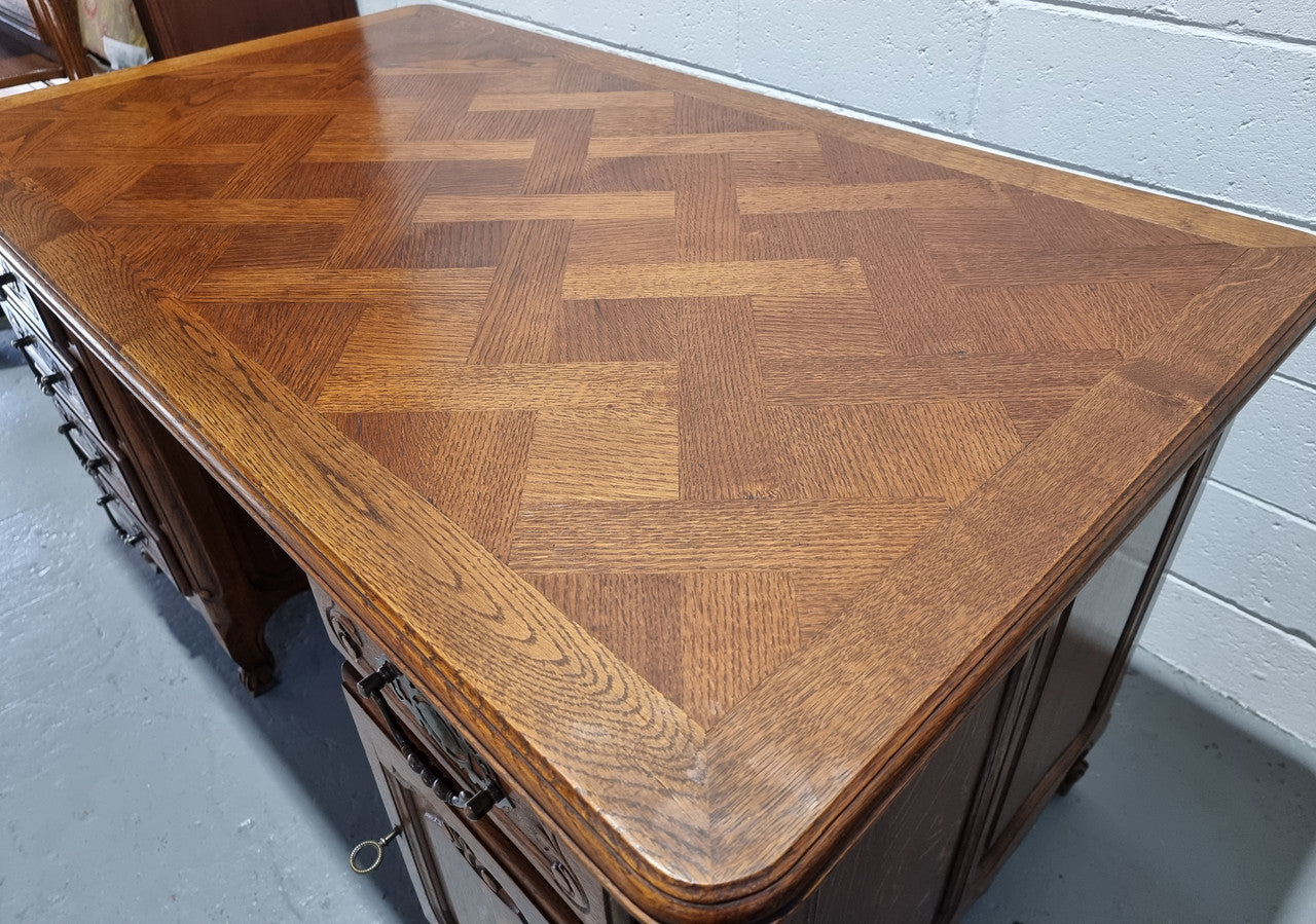 Beautifully carved french oak, faux partners desk with a lovely parquetry top and 6 drawers and 1 cupboard . In good original condition.