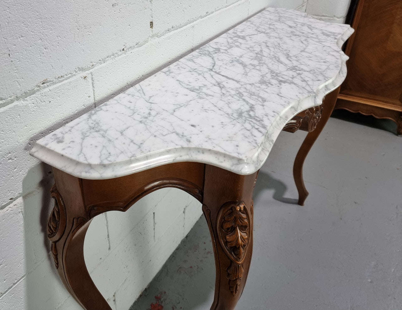 An elegant walnut French Louis XV style white marble top console table. It is in good original detailed condition.