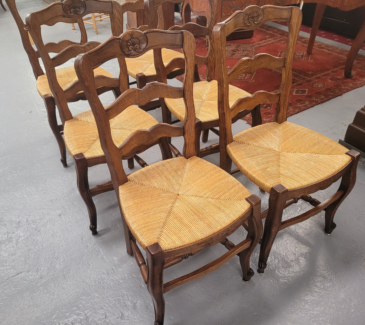 Set of six Louis XV style French Oak rush seat dining chairs. They are in good original detailed condition.