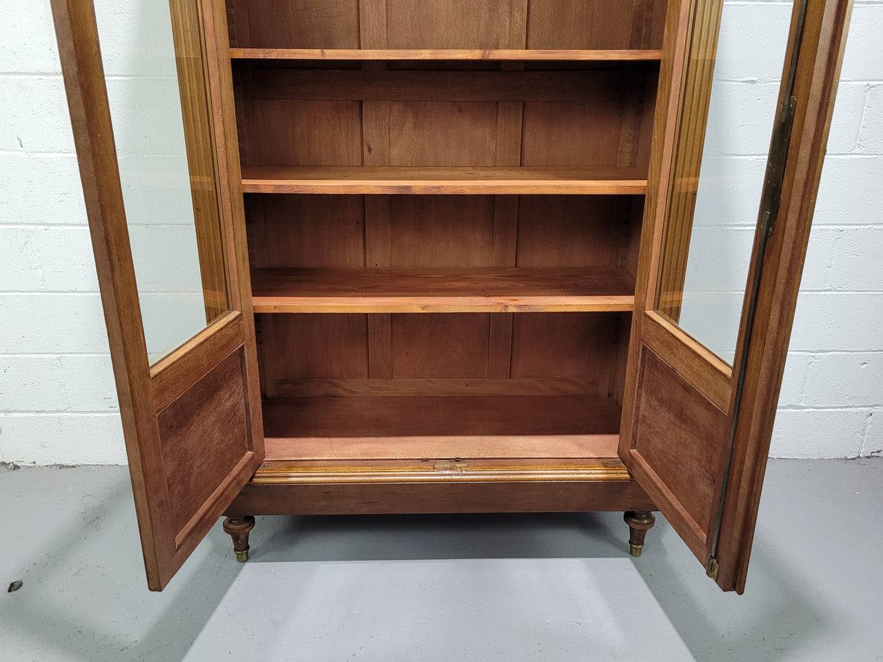 French Walnut two door bookcase with adjustable shelves and lovely ormolu details. It is in good original detailed condition.