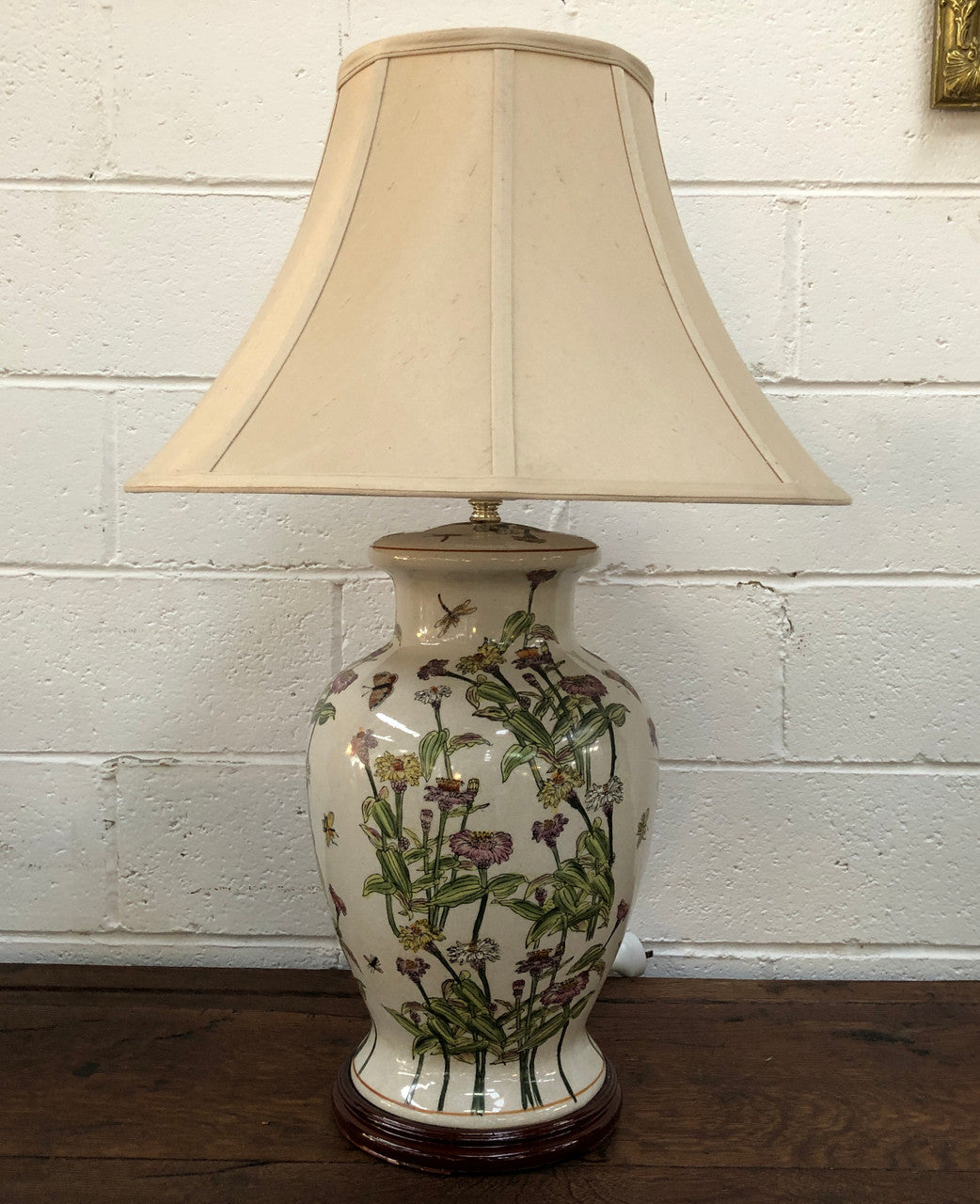 Contemporary ceramic lamp base decorated with daises & butterflies on a wooden base with shade.