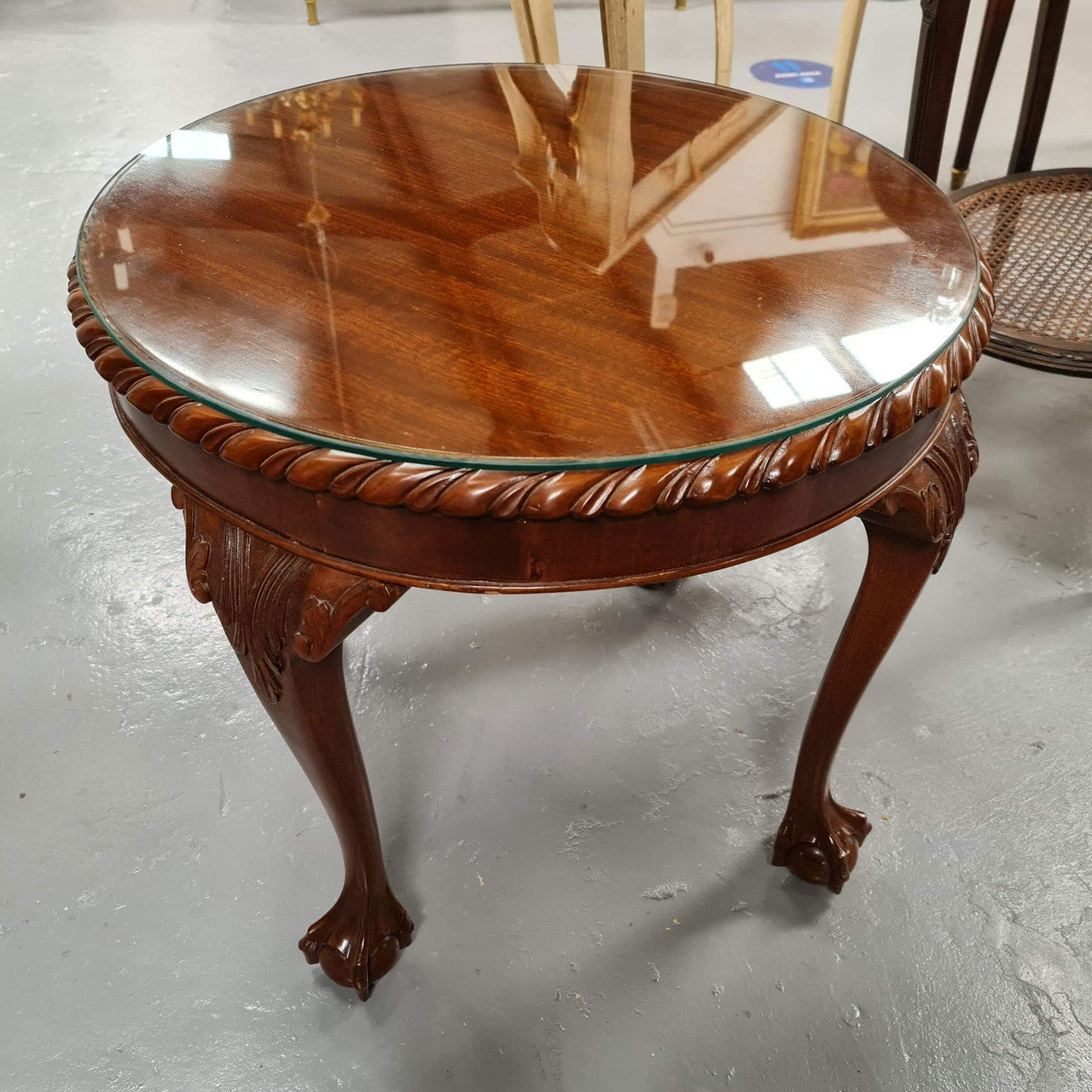 A beautiful round Mahogany Chippendale style coffee table with a glass top. In good original detailed condition.