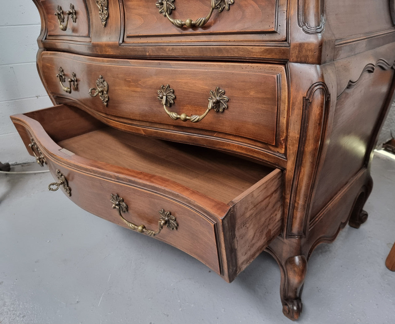 Impressive French Louis XV style Cherrywood four drawer commode, with a wooden top, two large drawers and two smaller drawers. Features attractive handles and a carved skirt and feet. In good original detailed condition.