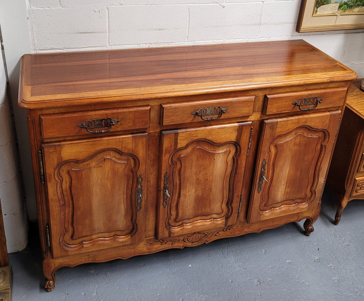 Beautiful French three door three drawer Louis XV style Cherrywood sideboard. It has a total of four adjustable shelves and comes with three keys. It has been sourced from France and is in good original detailed condition.