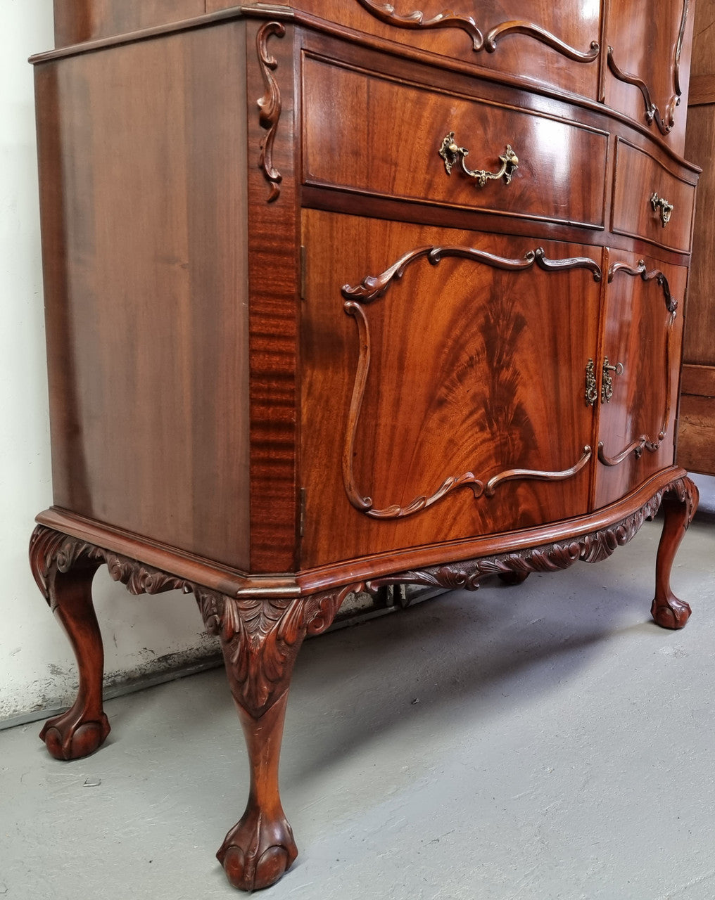 1950’s Chippendale Style Flame Mahogany Four door Bar. The top section has glass shelves and a mirrored pull out tray for storing glasses, decanters & serving etc. It also has a silver presentation plaque to the Mayor of Hawthorn 1958. The bottom section is for storage bottles etc. A stunning and practical piece.
