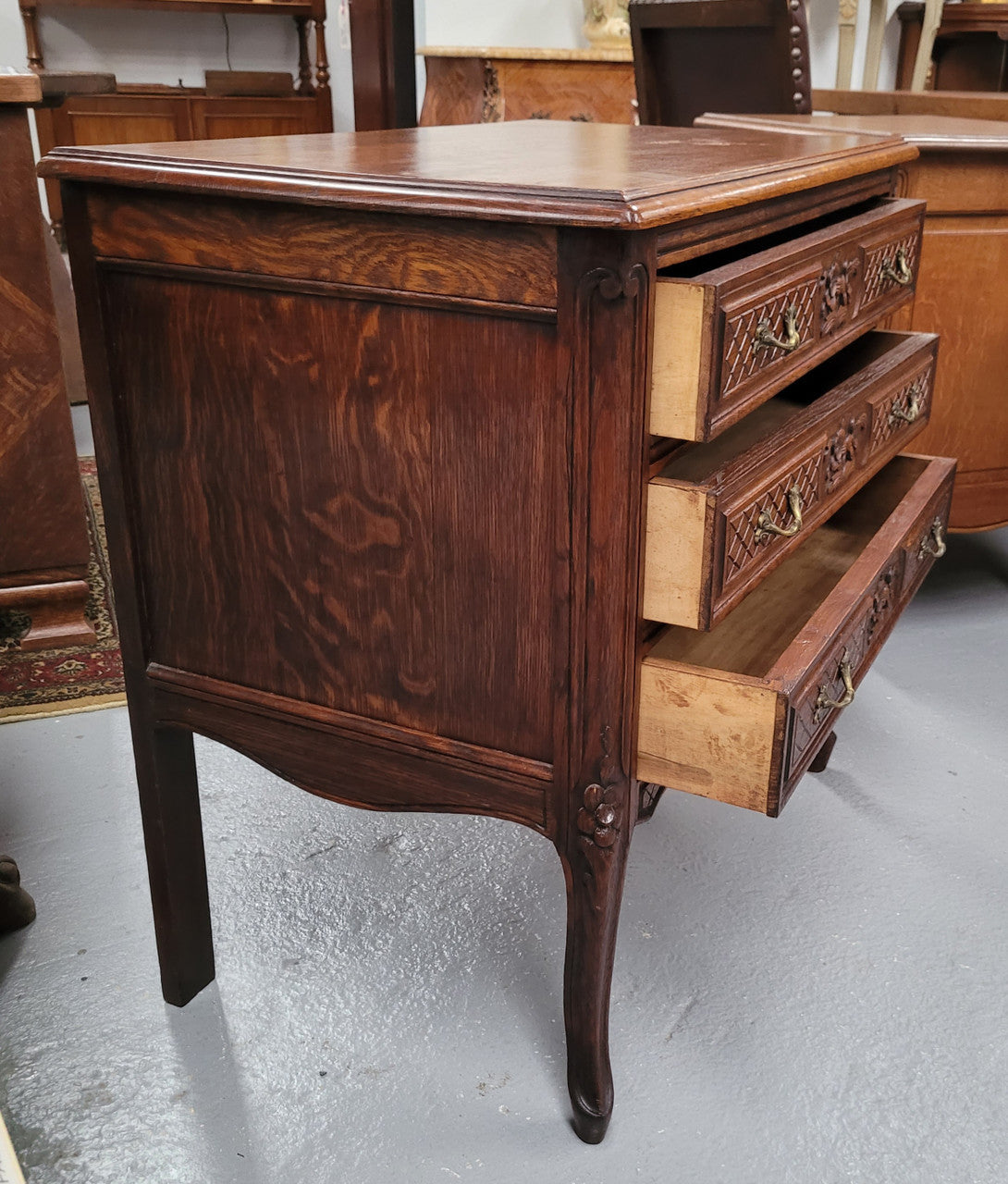 Rustic Louis XV style Oak petite three drawer chest featuring attractive carvings. It has been sourced locally and it is in good original detailed condition.