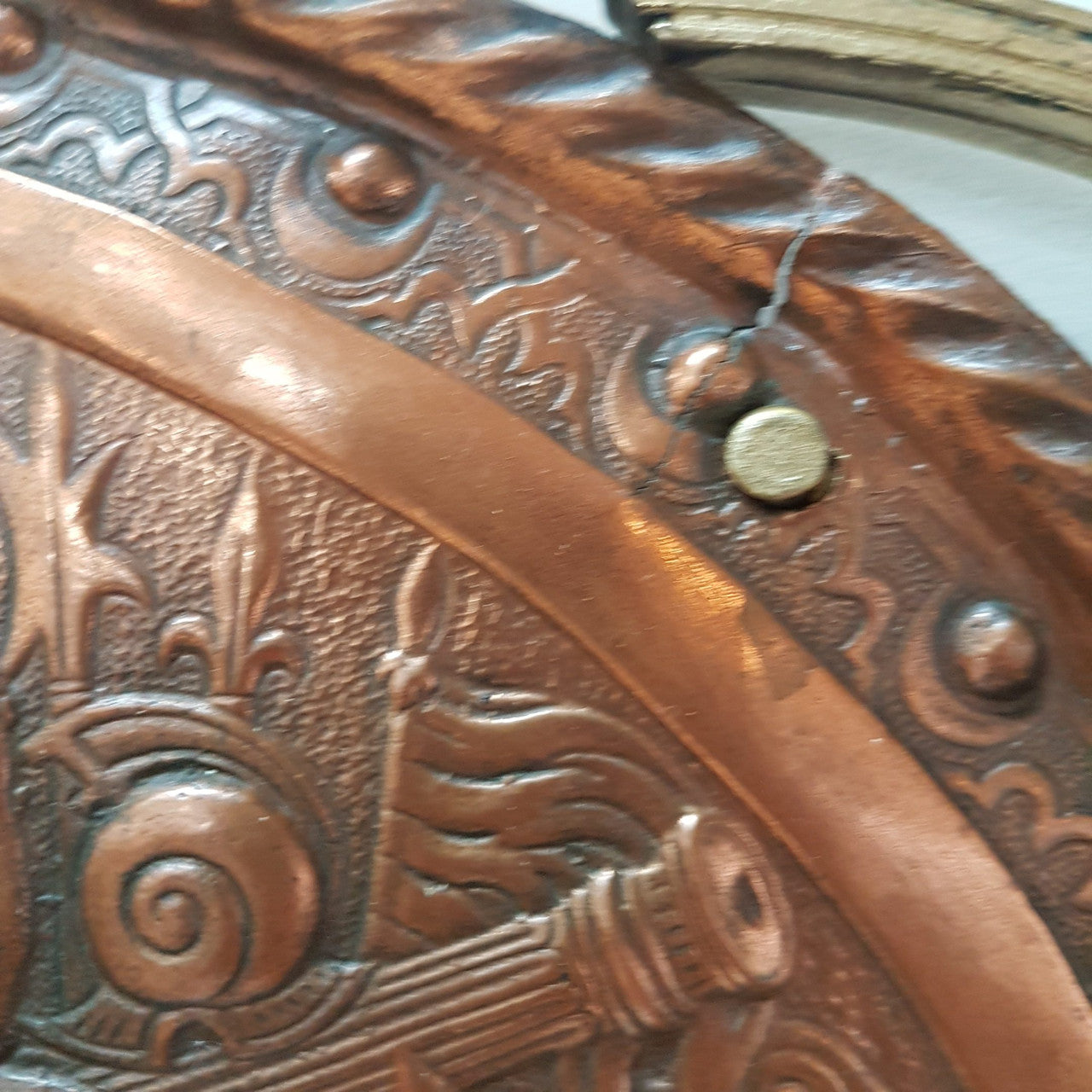 A beautiful European Antique highly detailed embossed copper shield with swords. Look closely to see the amazing detail in the shield of a fighting scene. It has brass handles on the steel swords. Is in good original condition with a slight crack (see photo).
