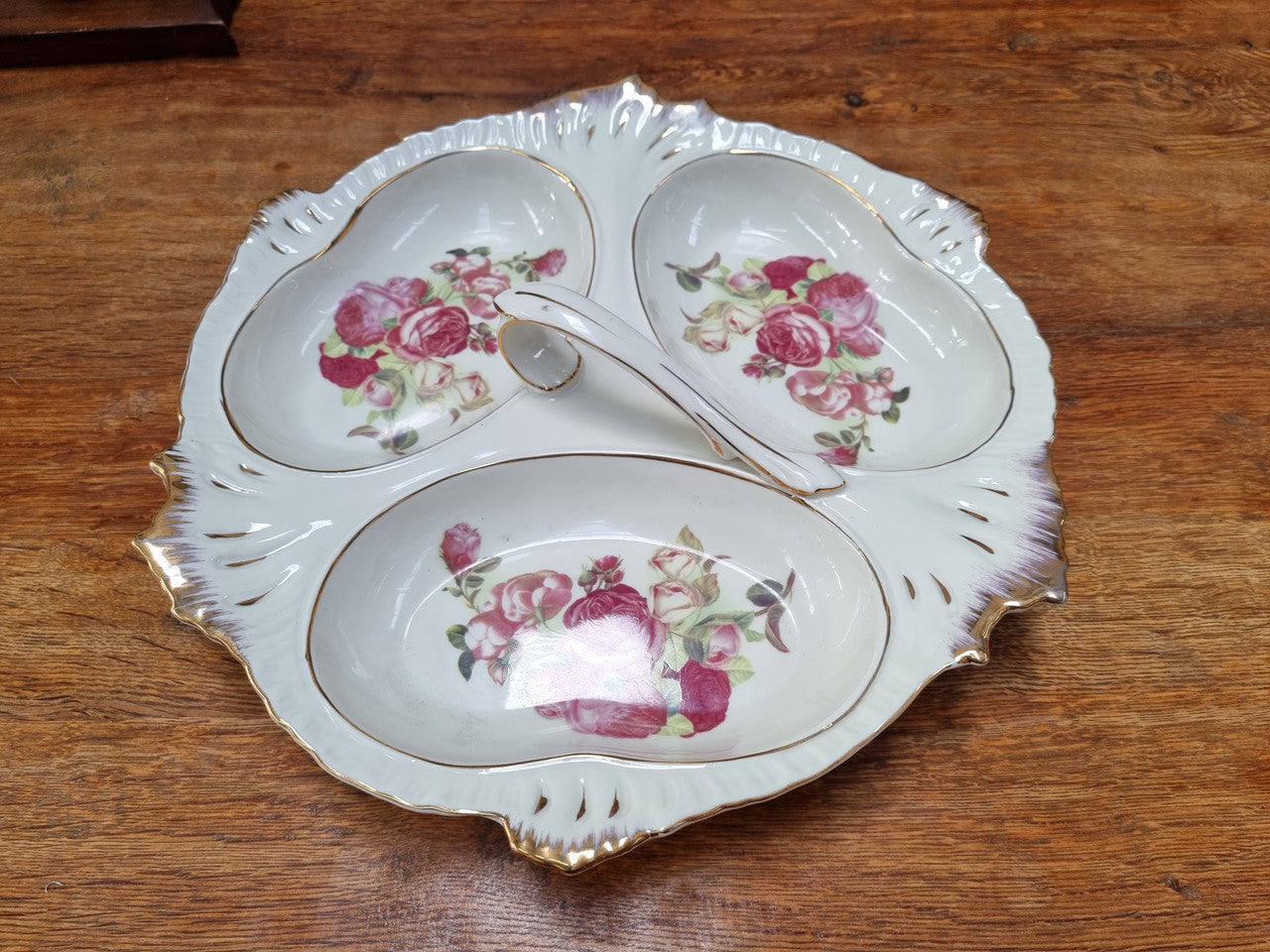 Vintage ceramic three sectional floral bowl with handle and gilt rim. Stamped underneath and in good original condition with no chips or cracks. Please view photos as they help form part of the description.