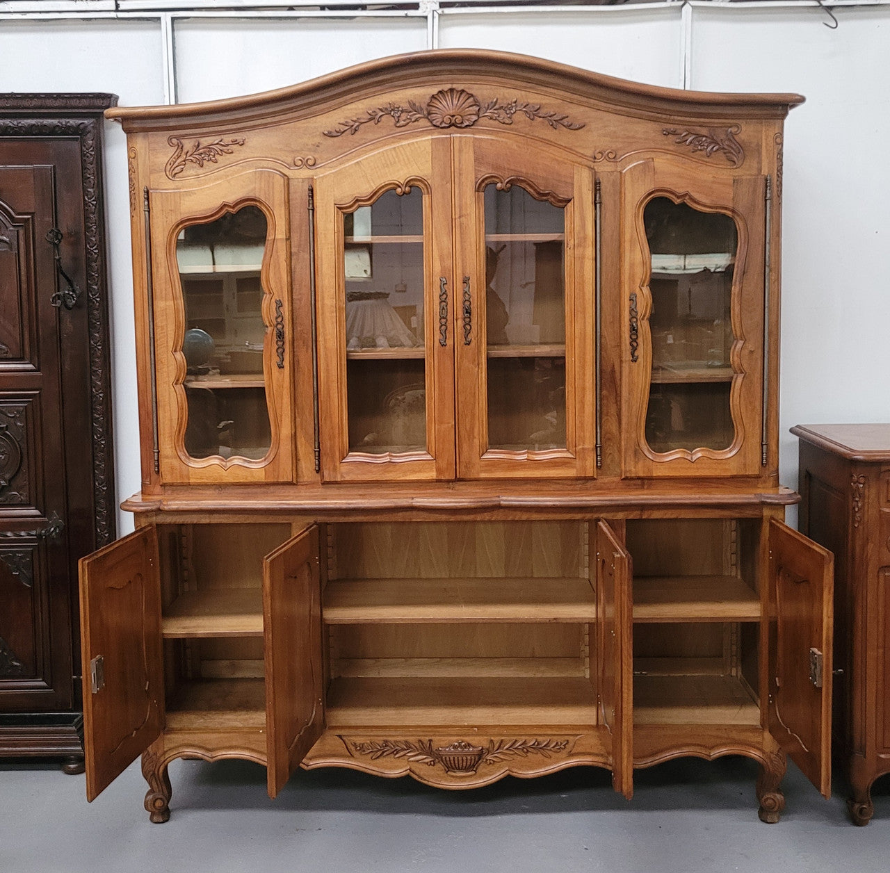 Magnificent French Walnut two-body four door display cabinet. Heaps of storage space with four glass doors at the top with shelves and four solid doors below also with shelving. It has been sourced from France and comes with a key for each door and all are lockable. In good original detailed condition.