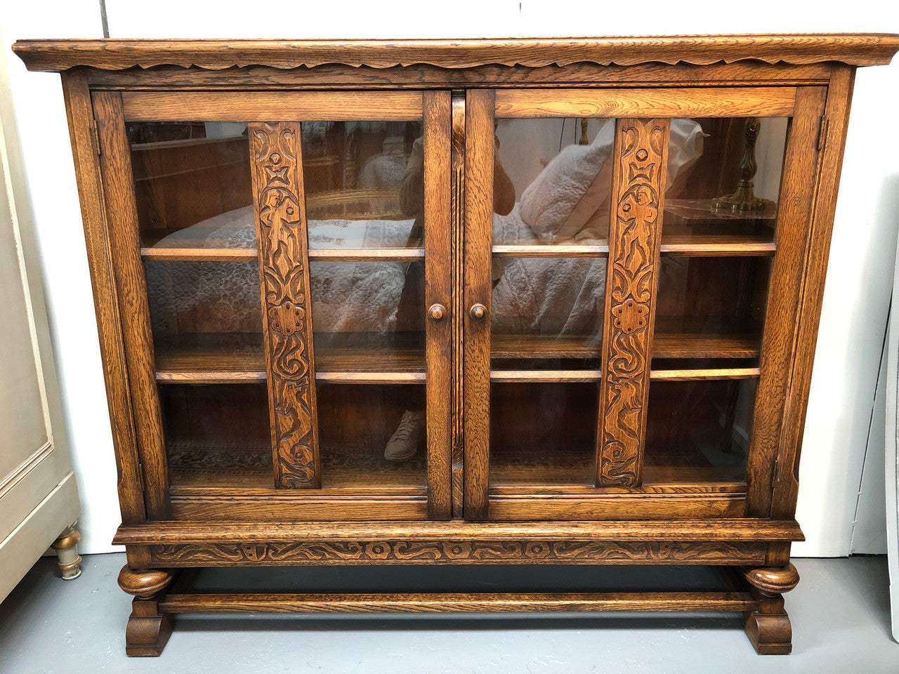 Lovely Two door bookcase sourced from France with two adjustable shelves on each side and of narrow proportions. It also has lovely detail carving and in good original detailed condition.