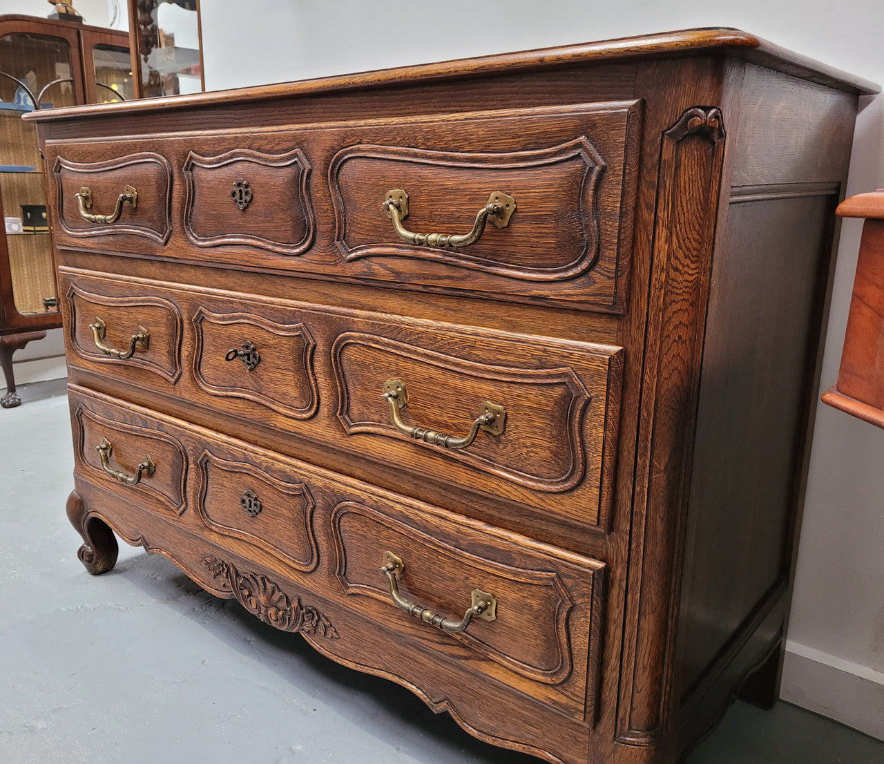 French Provincial Oak three drawer wooden top commode. It has elegant carvings and handles. It has been sourced from France and is in good original detailed condition.