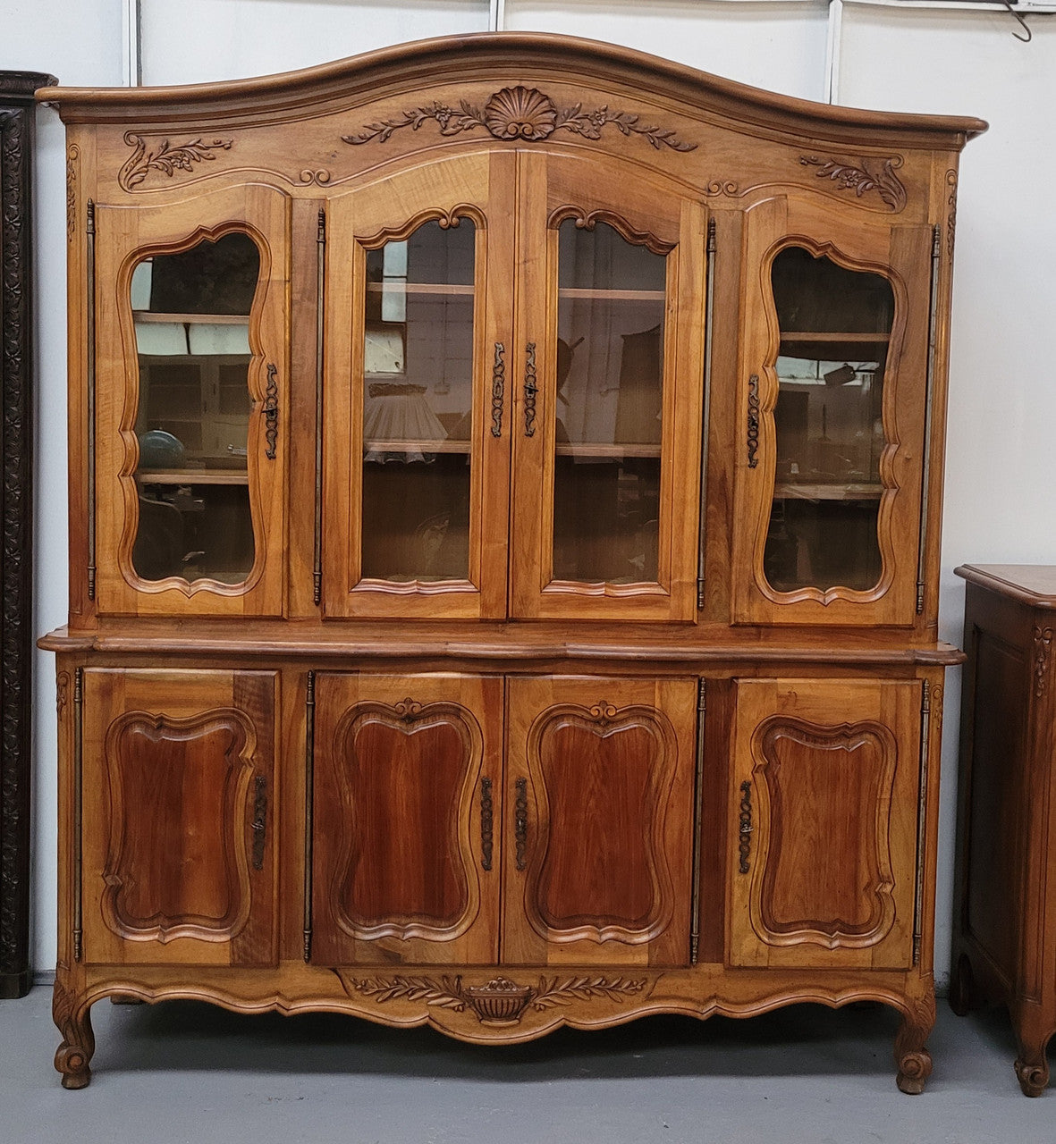 Magnificent French Walnut two-body four door display cabinet. Heaps of storage space with four glass doors at the top with shelves and four solid doors below also with shelving. It has been sourced from France and comes with a key for each door and all are lockable. In good original detailed condition.