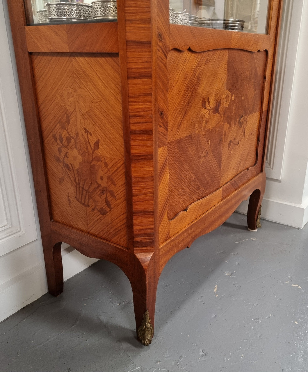 Beautiful French walnut inlaid vitrine with a lovely marquetry design and ormolu mounts. Has a beautiful coloured marble top and two glass shelves. In good original condition.