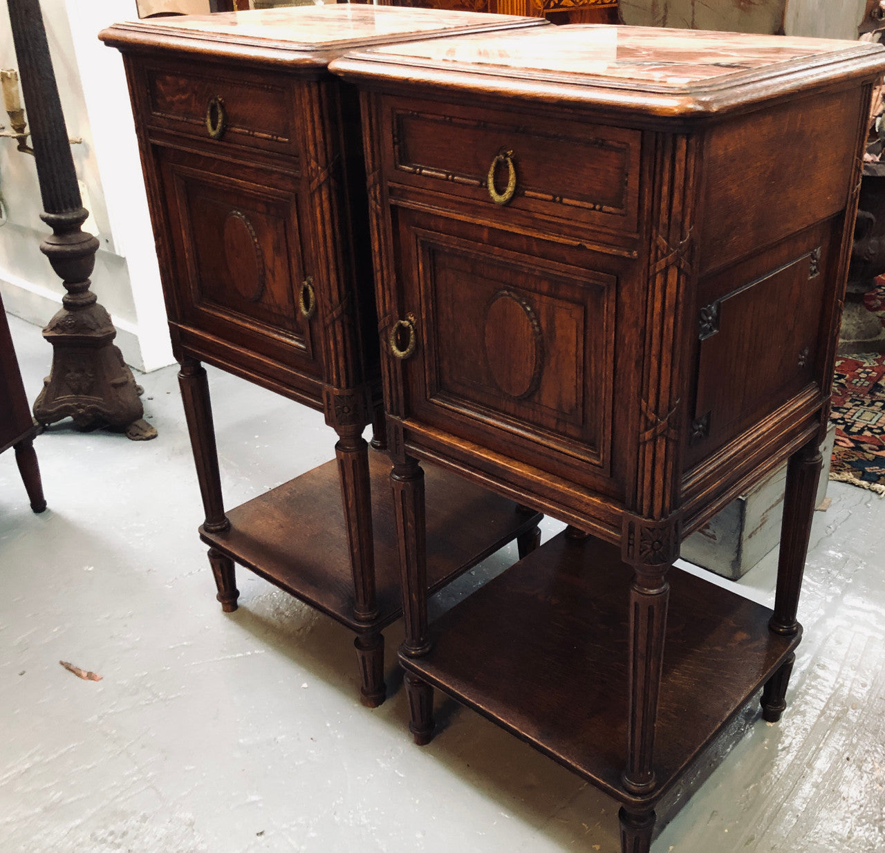 Lovely pair of French Oak Louis XVI style bedside cabinets with inset marble tops a drawer and a cupboard for storage. In good original detailed condition.