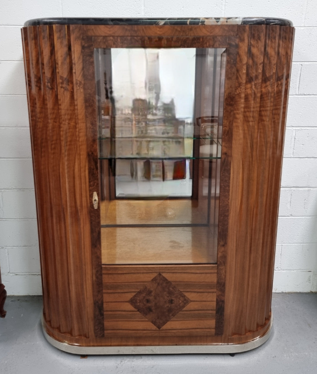 Stunning French Art Deco figured Walnut with Portoro marble top cocktail cabinet. Features chrome trim on base and glass display in door. It is in fully restored condition.