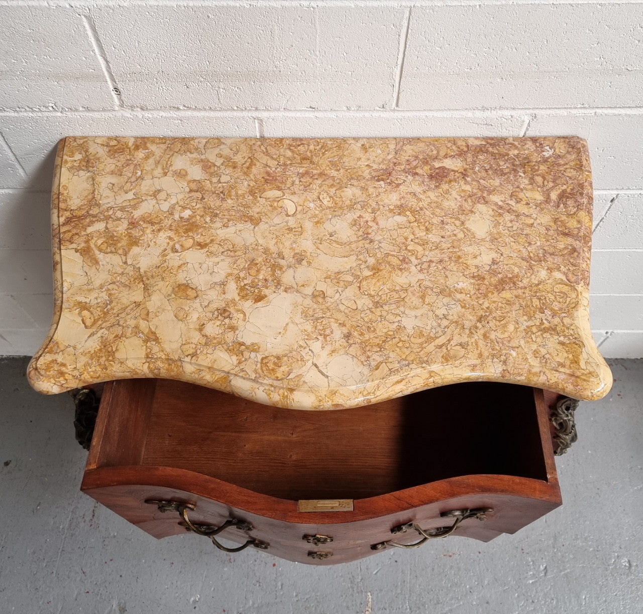 A timeless and compact French Louis XV style two drawer Kingwood marquetry inlaid commode. It features a stunning marble marble top and decorative mounts. The compact design of this commode ensures versatility, making it a perfect addition to any living space, bedroom or hallway. It has been sourced directly from France and is in good original detailed condition.