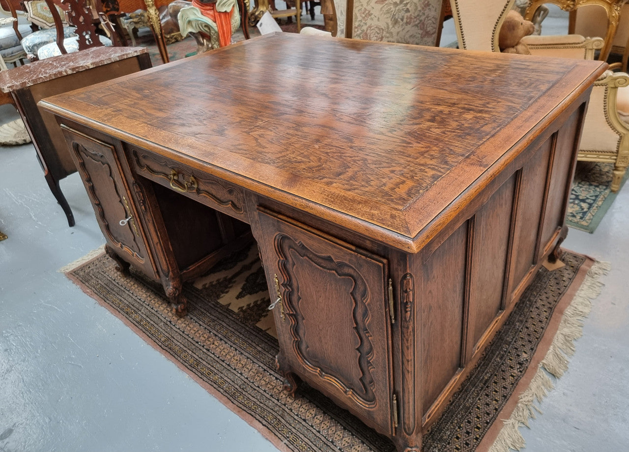 Fabulous Louis XV style French Oak beautifully carved full partners desk. Both sides have a functioning drawer in the middle and two cupboards either side. On both sides one cupboard door opens up to four smaller internal drawers. Plenty of storage space and a large top surface to work on. It is in good original detailed condition.