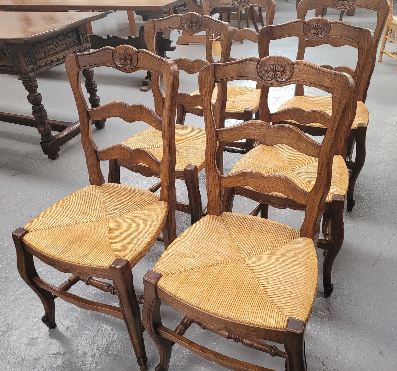 Set of six Louis XV style French Oak rush seat dining chairs. They are in good original detailed condition.