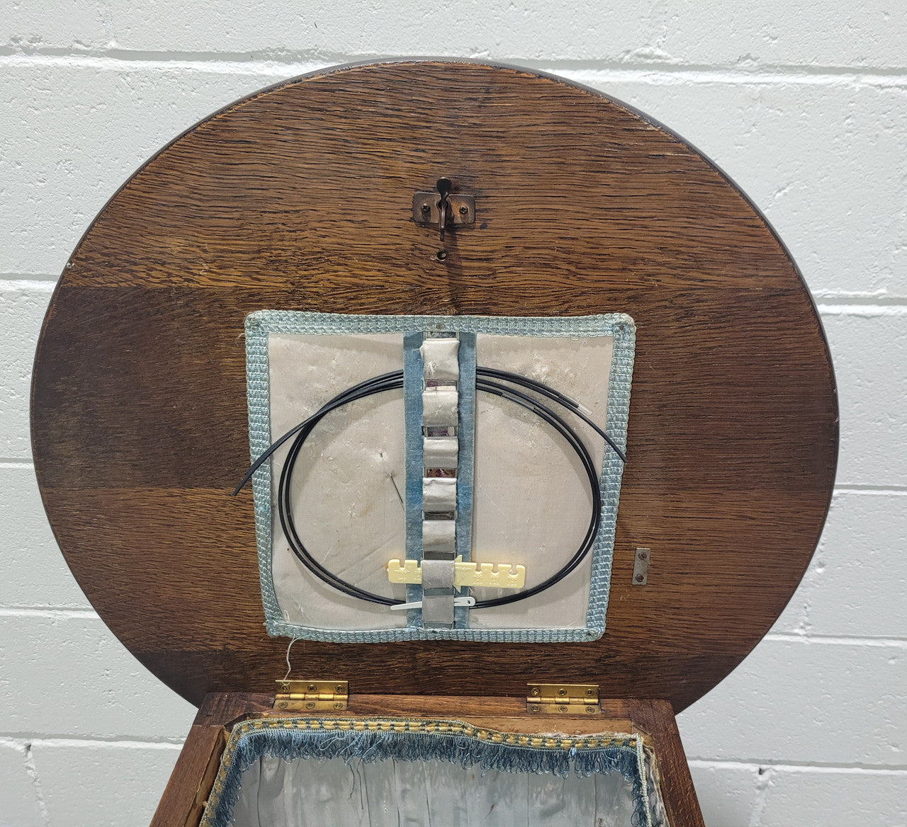 Fabulous round oak side table which also has a hidden sewing box underneath with lovely original blue satin lining and Includes pictured sewing items. It is in good original condition.