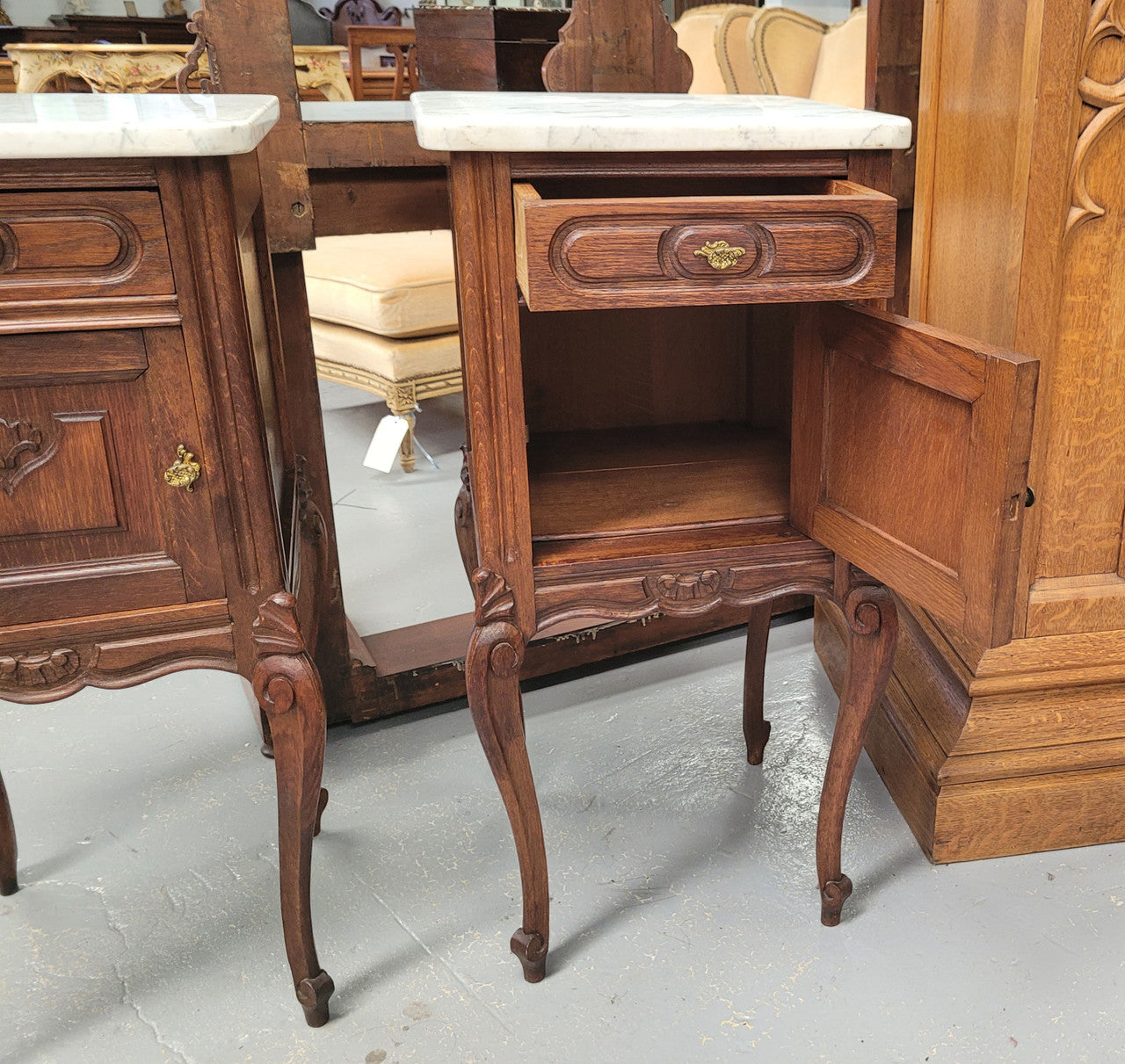 Pair French oak Louis XV style white carrera marble top bedside cabinets. Consisting of one drawer and one cupboard each on elegant legs. Circa: 1900's