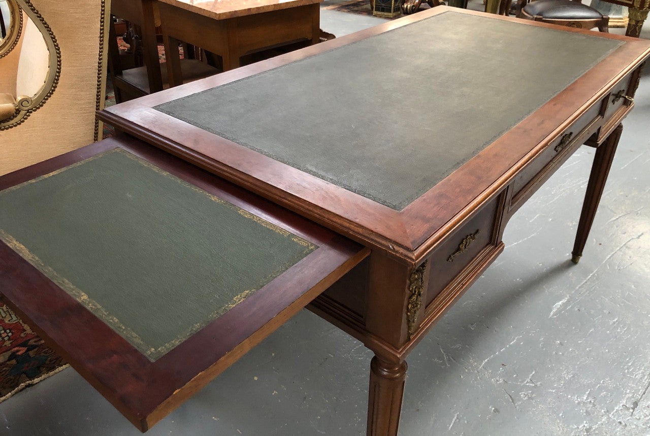 Lovely French Mahogany Louis XVI style leather top desk. With beautiful ormolu details and three drawers. There are also two slides on either side with tooled leather tops and in good original detailed condition.